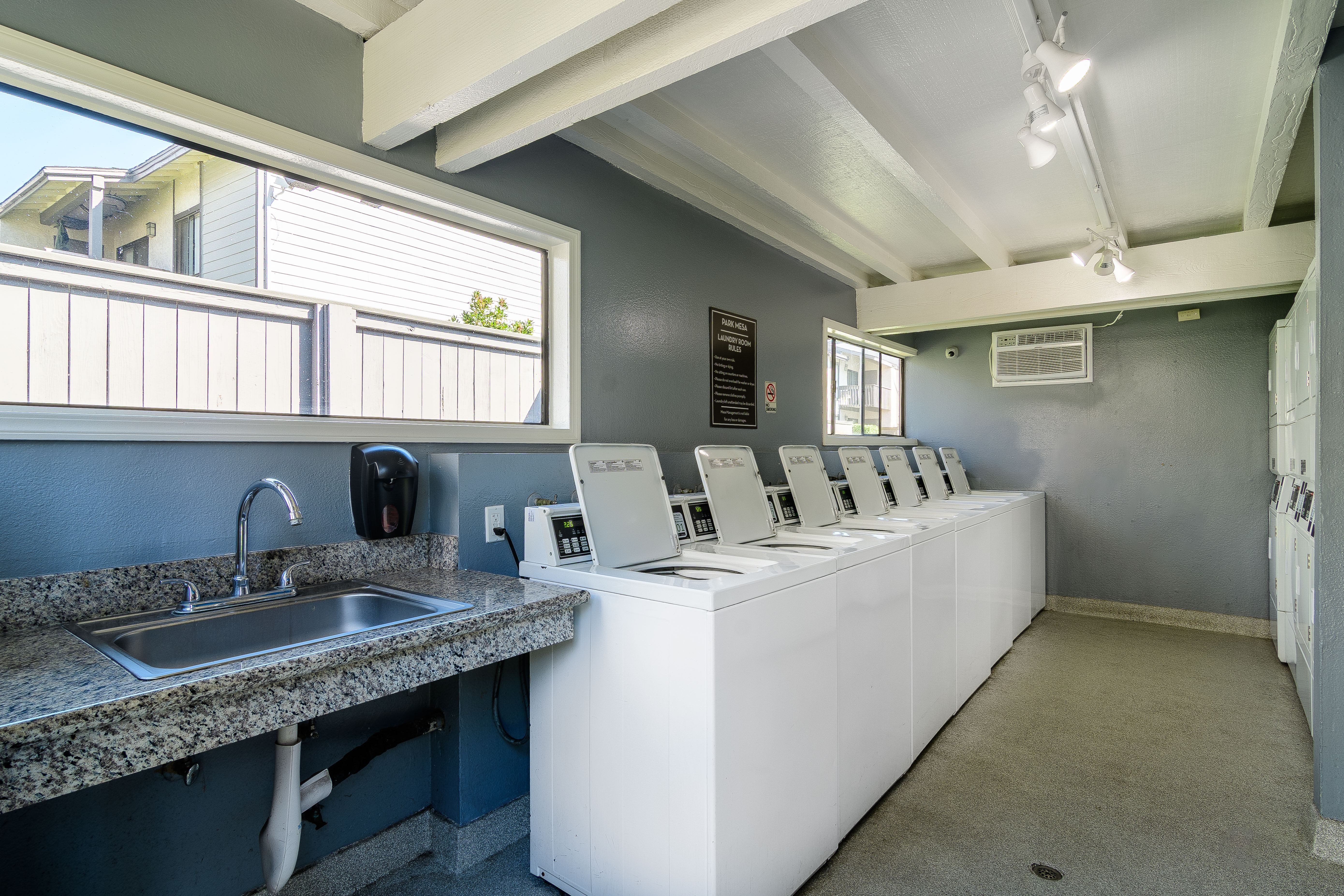 A public restroom with a row of sinks and mirrors.